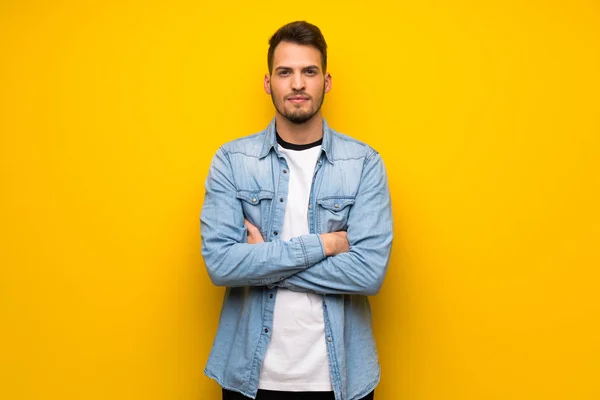 Handsome man over yellow wall portrait