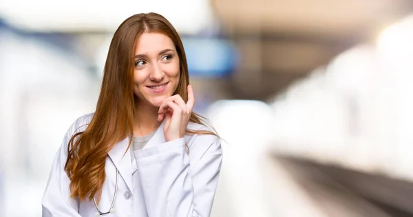 Médico Pelirrojo Mujer Pensando Una Idea Mientras Mira Hacia Arriba — Foto de Stock