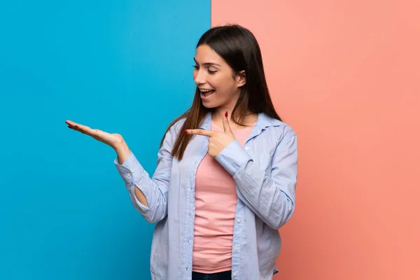 Mujer Joven Sobre Pared Rosa Azul Sosteniendo Espacio Copia Imaginario —  Fotos de Stock