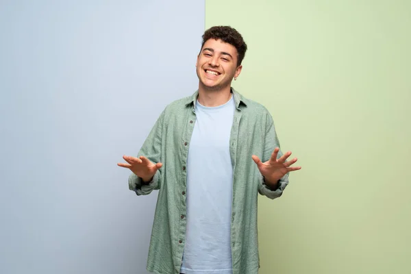 Junger Mann Über Blauem Und Grünem Hintergrund Lächelt — Stockfoto