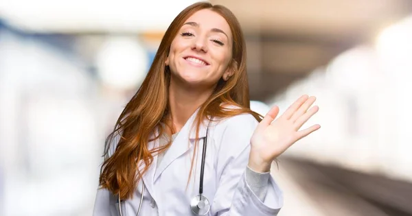 Ruda Kobieta Lekarz Pozdrawiając Ręką Happy Wyrażenie Szpitalu — Zdjęcie stockowe