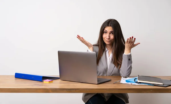Business woman in a office making doubts gesture