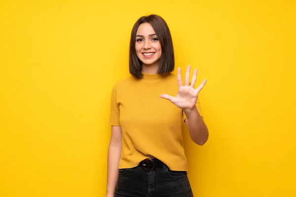 Νεαρή Γυναίκα Πάνω Από Κίτρινο Τοίχο Μετρώντας Πέντε Δάχτυλα — Φωτογραφία Αρχείου