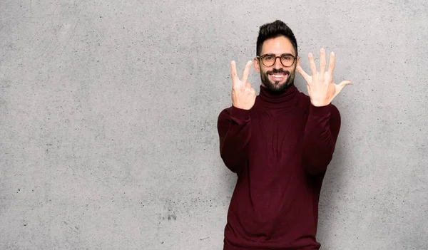 Pohledný Muž Brýlemi Počítání Sedmi Prsty Nad Texturou Nástěnné — Stock fotografie
