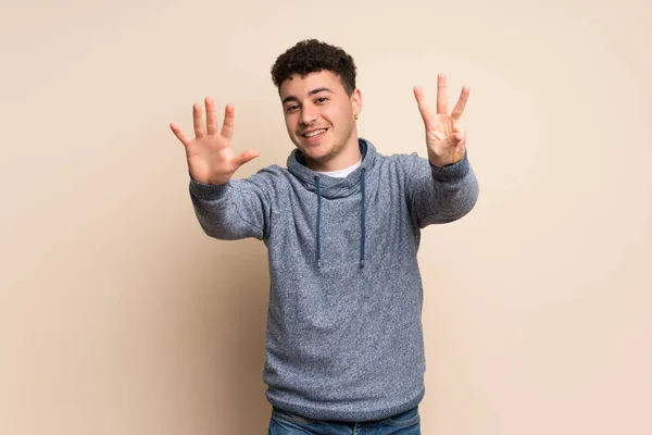 Mladý Muž Nad Izolované Stěny Osmi Prsty — Stock fotografie