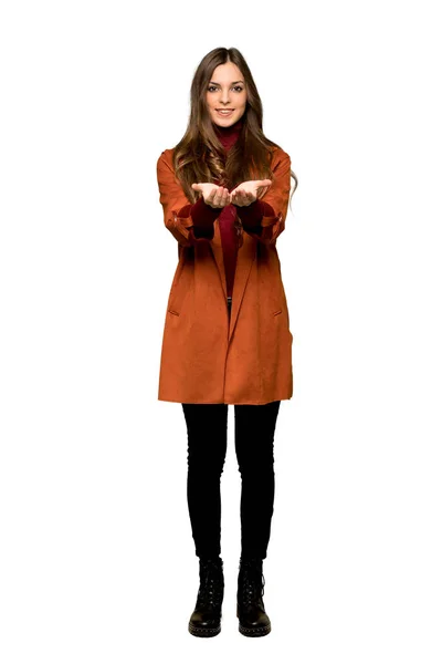 孤立した白い背景に広告を挿入する Copyspace を保持するには 架空の手のひらコートを持つ若い女性のフルレングスのショット — ストック写真