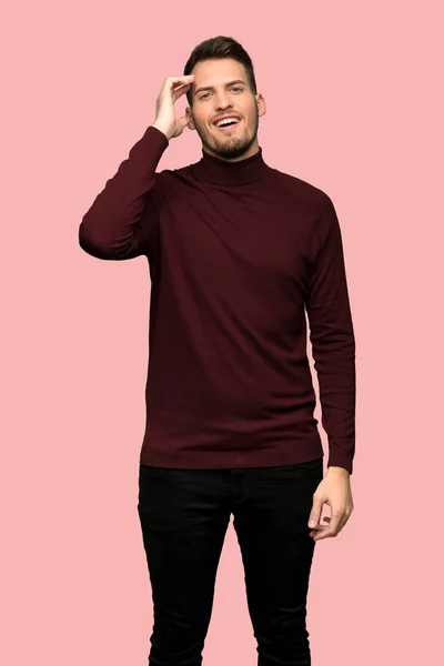 Man with turtleneck sweater has just realized something and has intending the solution over pink background