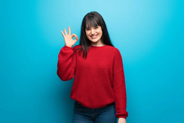 Vrouw Met Rode Trui Blauwe Muur Tonen Teken Met Vingers — Stockfoto