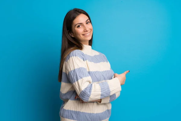 Jonge Vrouw Blauwe Muur Terug Met Wijsvinger Wijzen — Stockfoto