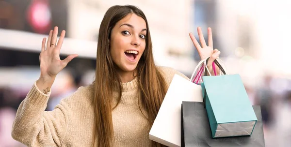 Chica Joven Con Bolsas Compras Contando Ocho Con Los Dedos — Foto de Stock