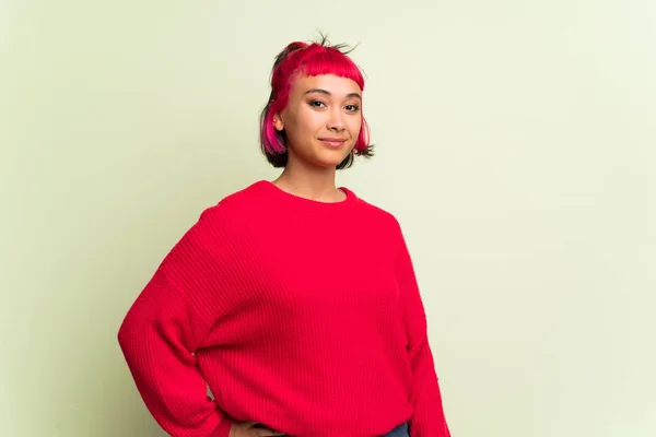赤いセーター ヒップで腕のポーズと笑顔を持つ若い女性 — ストック写真