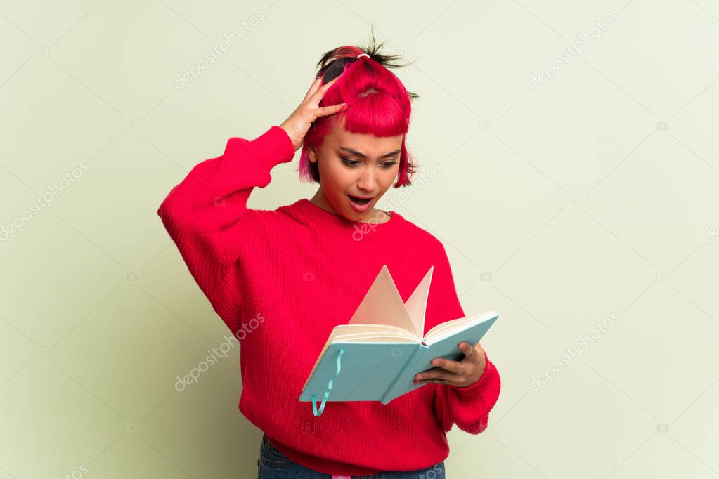 Young woman with red sweater surprised while enjoying reading a book