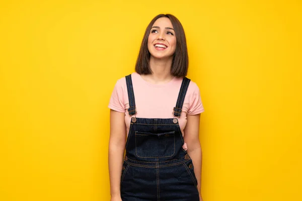 Üzerinde Sarı Duvar Gülümseyen Genç Kadın — Stok fotoğraf