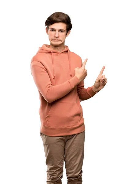 Tiener Man Met Sweatshirt Wijzen Naar Kant Geïsoleerde Witte Achtergrond — Stockfoto