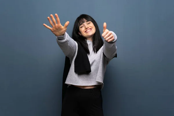 Young sport woman counting six with fingers