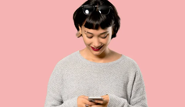 Молодая Женщина Короткими Волосами Отправляет Сообщение Мобильного Изолированном Розовом Фоне — стоковое фото