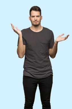 Adam siyah gömlek mutsuz çünkü bir şey üzerinde mavi arka plan değil anlamak