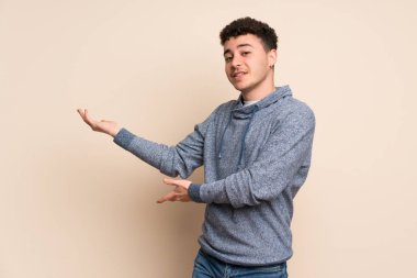 Genç adam uzanan eller yanına gelmek için davet için yalıtılmış duvar üzerinde