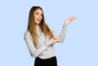 genç kız uzanan eller üzerinde mavi arka plan gelmek davet için yan