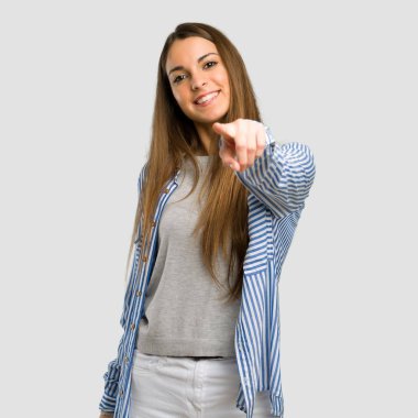 Çizgili gömlekli ile genç kız sana kendinden emin bir ifade ile izole gri arka plan üzerinde puan parmak