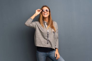 Gri arka plan ile gözlük ve sürpriz sarışın kadın