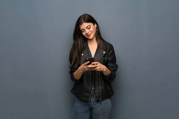 Menina Adolescente Sobre Parede Cinza Enviando Uma Mensagem Com Celular — Fotografia de Stock