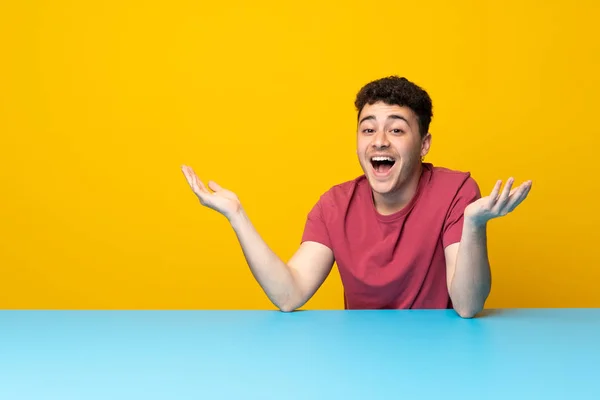 Jovem Com Parede Colorida Mesa Com Expressão Facial Chocada — Fotografia de Stock