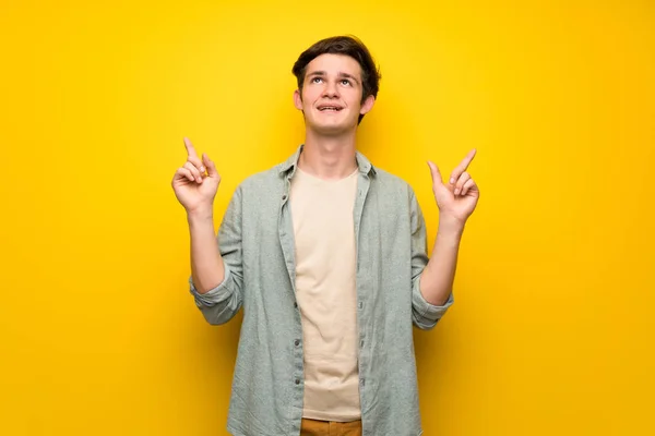 Dospívající Muž Nad Žluté Zdi Polohovací Ukazováčkem Skvělý Nápad — Stock fotografie