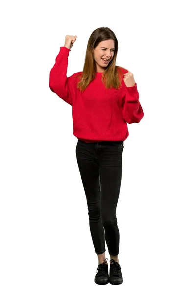 孤立した白い背景上の勝利を祝う赤いセーターを持つ若い女性のフルレングス ショット — ストック写真