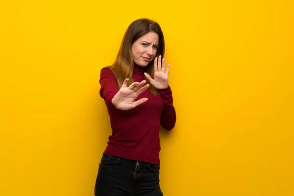 Mujer Con Cuello Alto Sobre Pared Amarilla Nerviosa Asustada Estirando —  Fotos de Stock