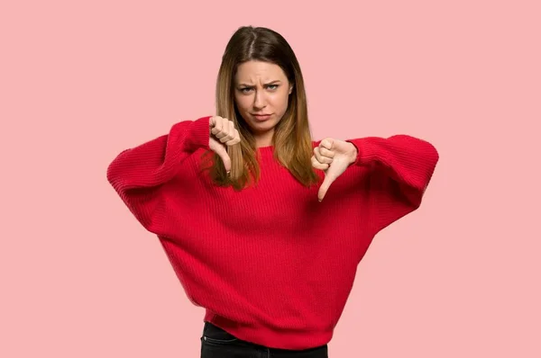 Jonge Vrouw Met Rode Trui Tonen Duim Omlaag Geïsoleerde Roze — Stockfoto