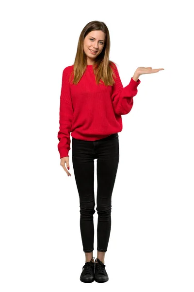 分離の白い背景の上に広告を挿入する Copyspace を保持するには 架空の手のひら赤いセーターを持つ若い女性のフルレングス ショット — ストック写真