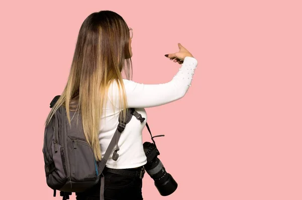 Молодая Фотограф Женщина Показывает Назад Указательным Пальцем Изолированном Розовом Фоне — стоковое фото