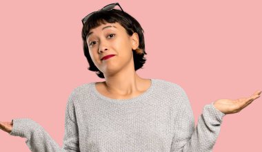 Mutsuz kısa saçlı genç kadın çünkü izole pembe bir arka plan üzerinde bir şey anlamıyor