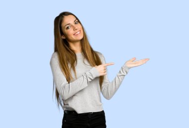 mavi arka plan bir reklamı eklemek için boşaltmak hayali avuç içinde tutan genç kız