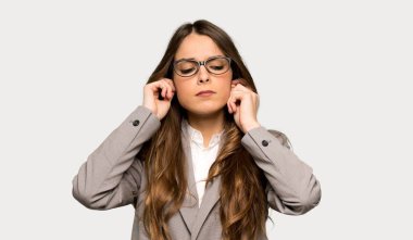 İş kadını elleriyle kulaklarını kapsayan. Hayal kırıklığı ifade izole gri arka plan üzerinde