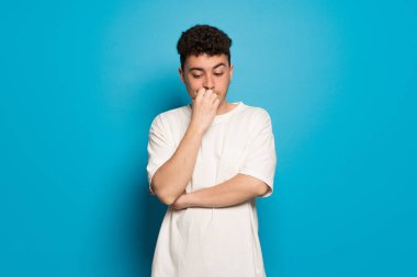 Mavi arka plan şüpheleri üzerinde genç adam