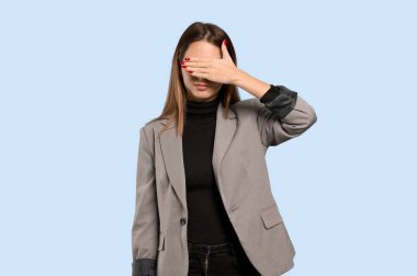 Gözleri eller tarafından kapsayan bir iş kadını. Bir şey izole mavi arka plan üzerinde görmek istiyor musunuz