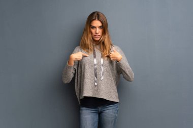 Sürpriz yüz ifadesi ile gri arka plan üzerinde sarışın kadın