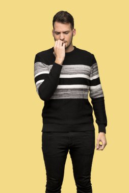 Yakışıklı adam sarı arka plan üzerinde şüpheleri