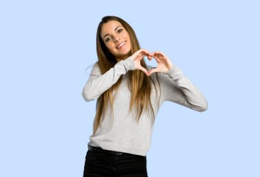 genç kız kalp simgesi ile yapım üzerinde mavi arka plan eller