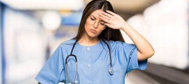 Bir hastanede yorgun ve hasta ifade ile genç hemşire