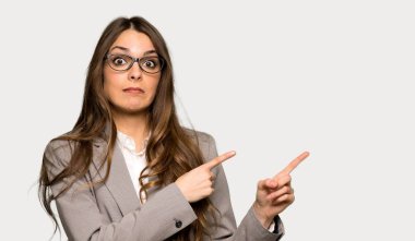 Korkmuş ve izole gri arka plan üzerinde tarafına işaret iş kadını