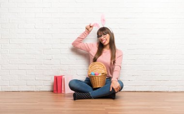 Katta oturan Paskalya tatili için tavşan kulaklı kadın komik ve çılgın yüz duygu yapar