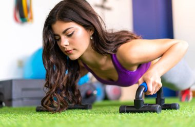 Genç kadın şınav bir spor salonunda spor