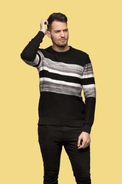 Yakışıklı adam sarı arka plan üzerinde kafa çizilmemesi süre şüpheleri