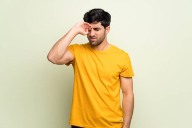 Genç adam yorgun ve hasta ifade ile pembe duvarın üzerinden