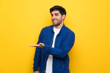 Mavi ceket ve süre seyir gülümseyen doğru bir fikir sunmak sarı duvarın üzerinden adamla
