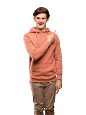 Genç adam ile şaşırttı ve yan izole beyaz arka plan üzerinde işaret kazak