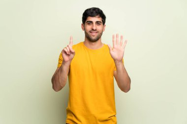 Genç adam pembe duvar altı parmak ile sayma